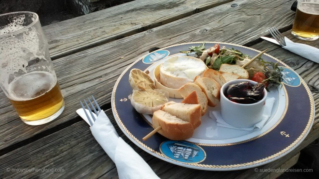 Goat cheese, here baked as brie with a chutney and bread on a salad