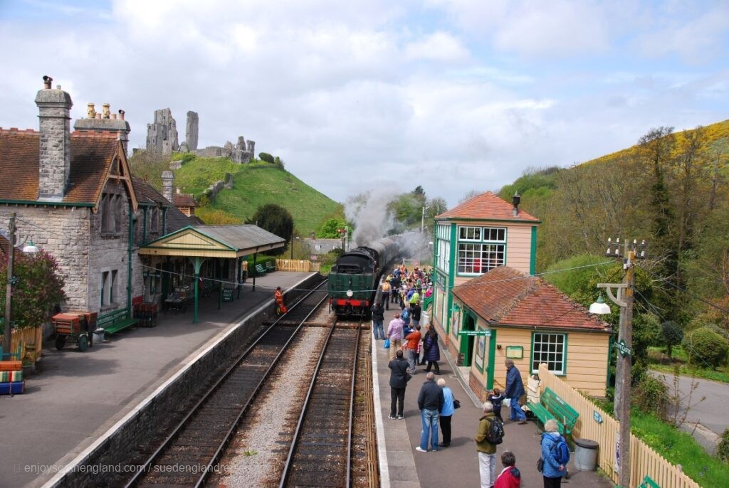 Corfe Castle on the left n the background behind the Swanage Railway
