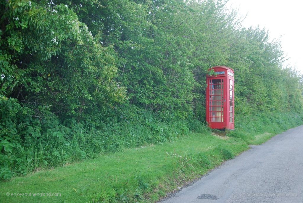 A very typical English phone booth looking lonely on a foggy country lane